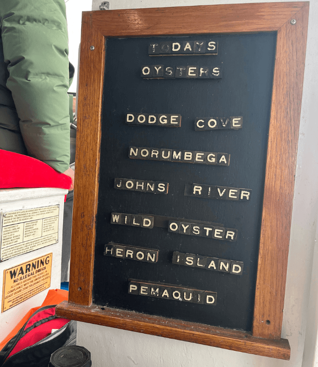 A chalkboard displays the day's oyster varieties: Dodge Cove, Norumbega, Johns River, Wild Oyster, Heron Island, and Pemaquid.